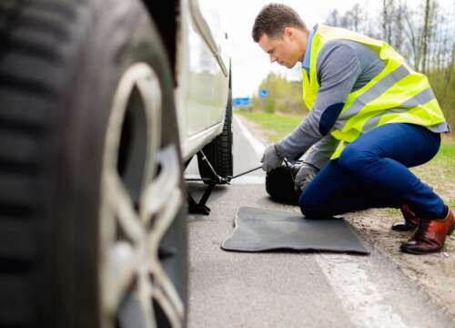 Man changing wheel on a roadside